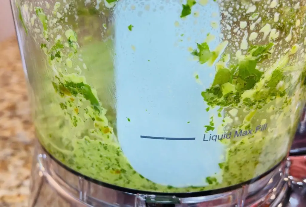 rubber spatula scraping sofrito off the side of food processor, substitute the olive oil with Domestic Gourmet Organic Annatto Oil - Aceite de Achiote for richer color and flavor
