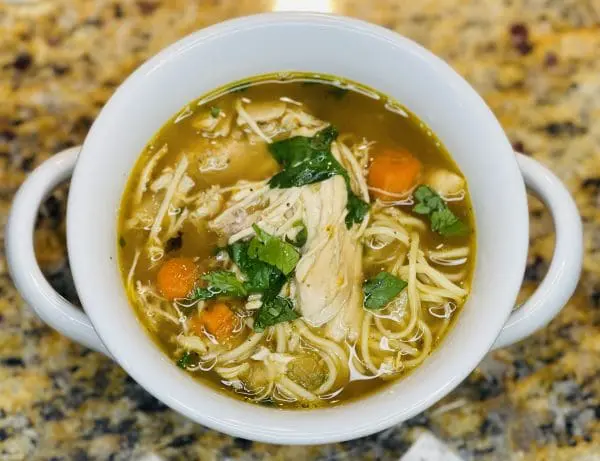 A bowl of sopa de pollo con fideos (Latin American chicken soup with noodles) made with Domestic Gourmet Organic Annatto Oil - Aceite de Achiote