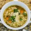 A bowl of sopa de pollo con fideos (Latin American chicken soup with noodles) made with Domestic Gourmet Organic Annatto Oil - Aceite de Achiote